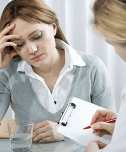 A woman sitting at a table with another person.