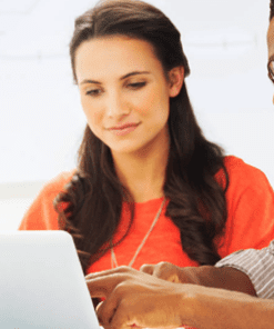 A woman and man looking at a laptop.