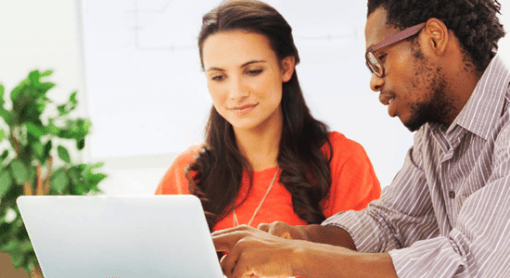 A woman and man looking at a laptop.