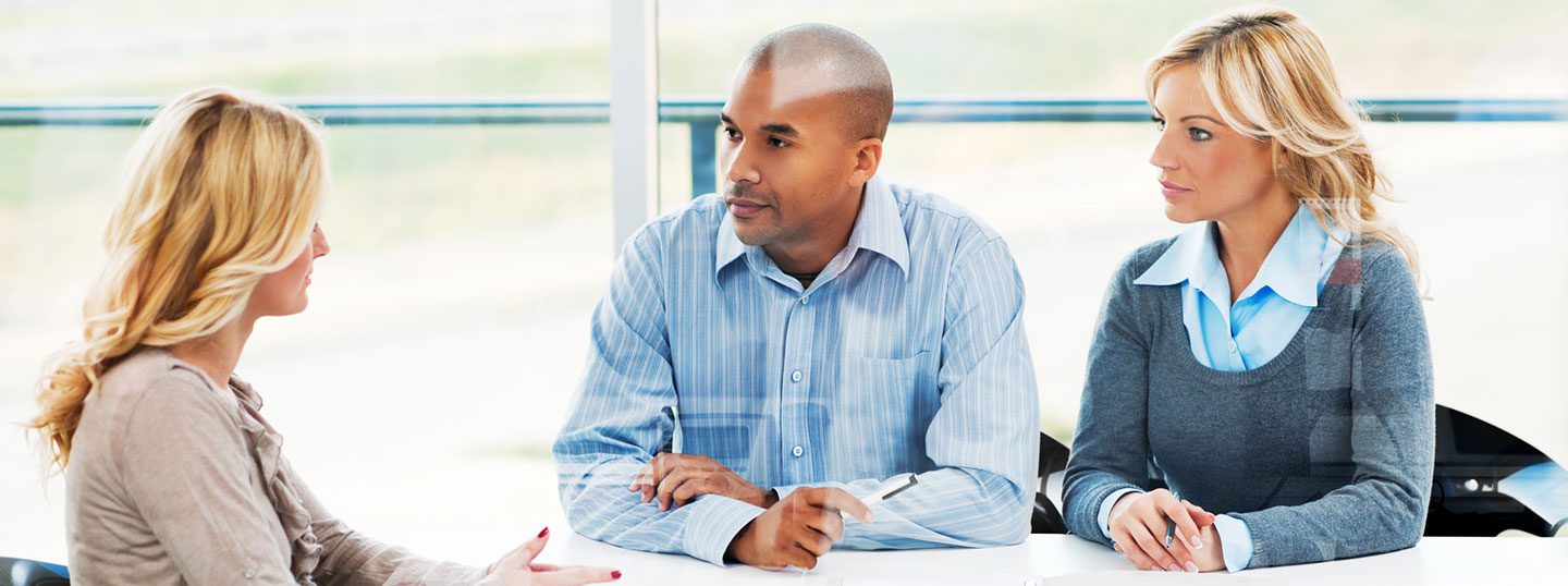 A man sitting at a table with his hand on the desk.