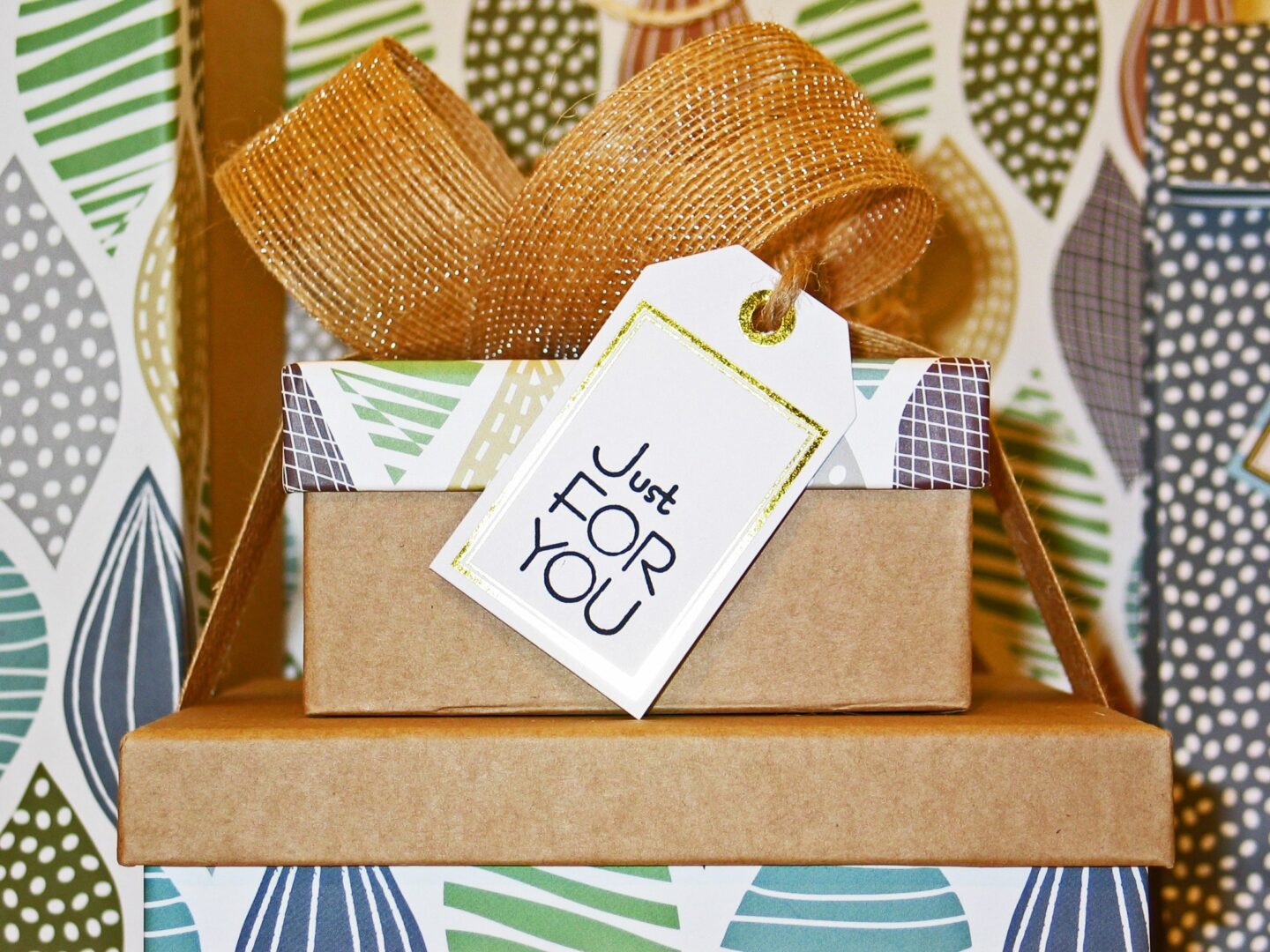 A gift box with a bow and tag on top of it.