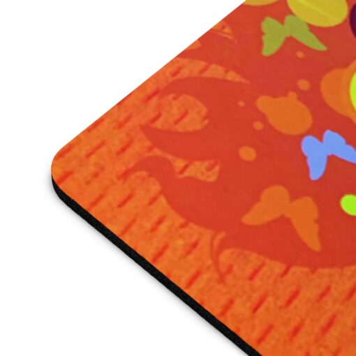 A close up of the bottom corner of an orange mouse pad.